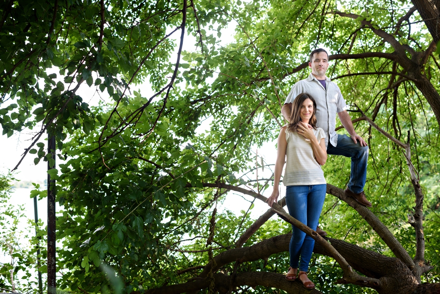 An engaged couple standing in a tree during their fishtown engagement session.